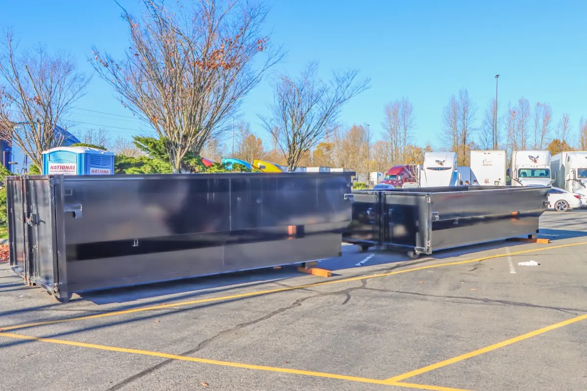 Professional dumpster rental service with roll-off container on residential driveway in White Lake